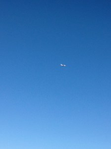 A lone plane slicing through the cloudless blue sky of summer.